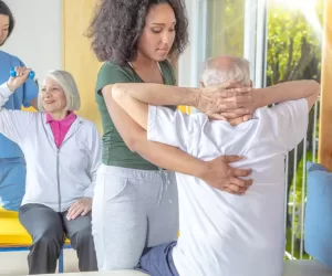 Couple,Of,Nurses,Helping,Active,Senior,Couple,At,Rehab,Gym.